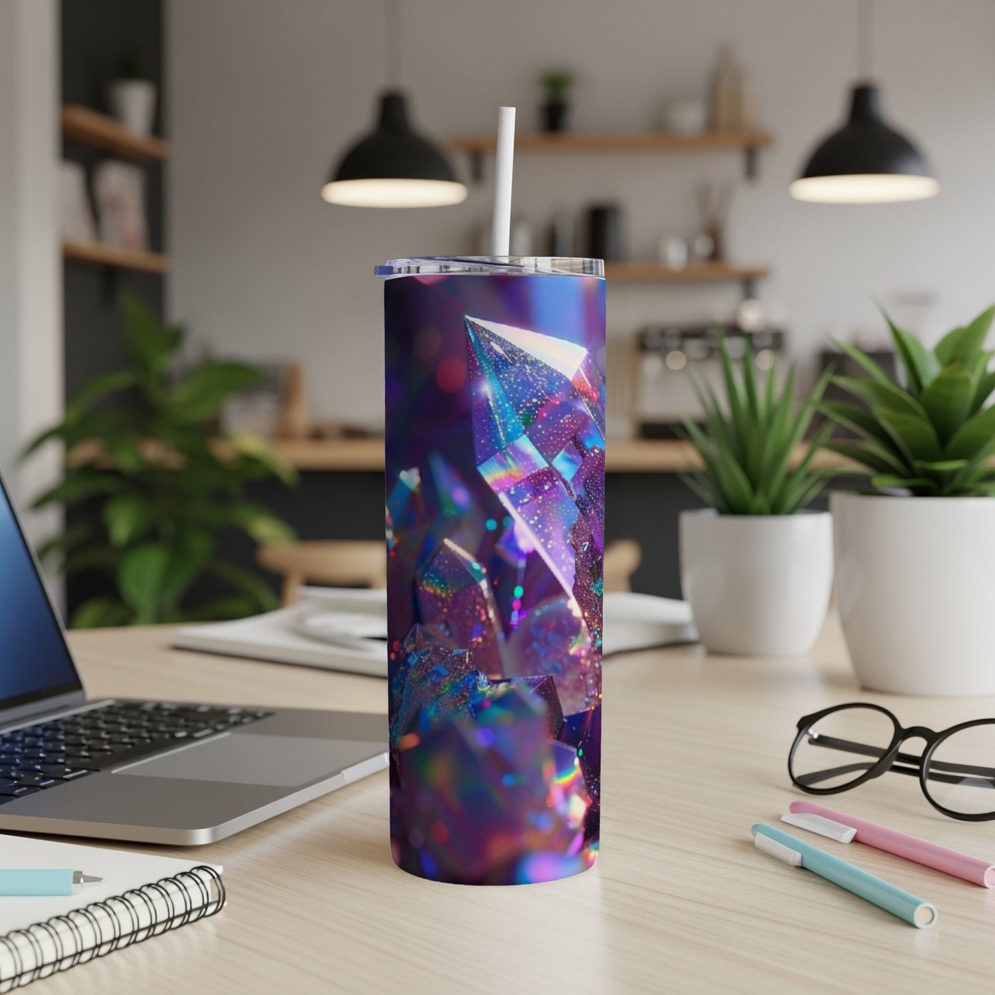 Iridescent crystal tumbler with straw on a desk.