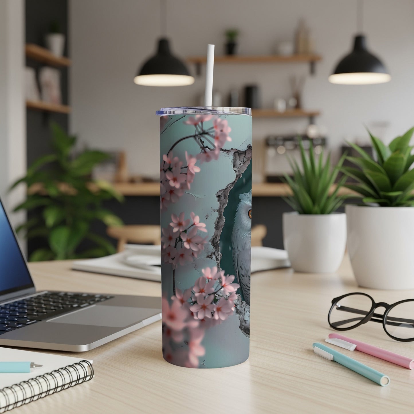 White owl with pink blossoms on a blue and grey tumbler with a straw.