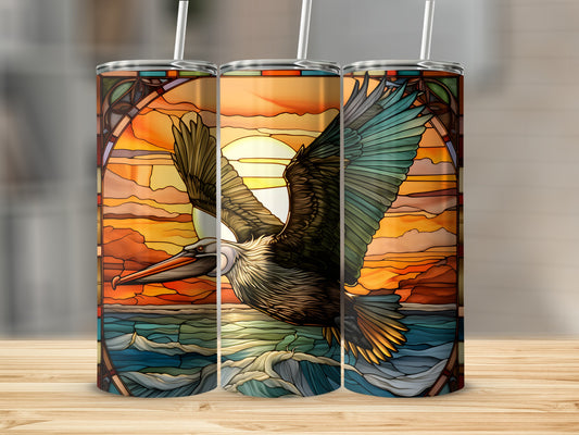 Three tumblers featuring a stained-glass pelican flying over ocean waves at sunset.