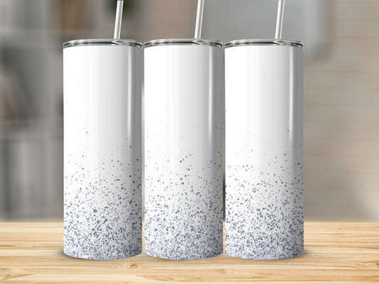 Three white tumblers with speckled blue glitter accents on a wooden surface.