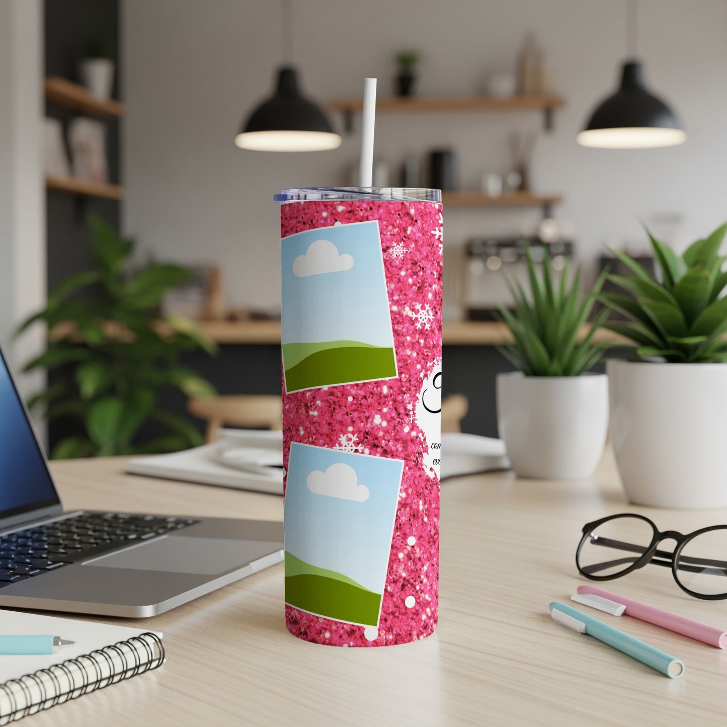 Pink glitter tumbler with photos, snowflakes, and text on a desk.