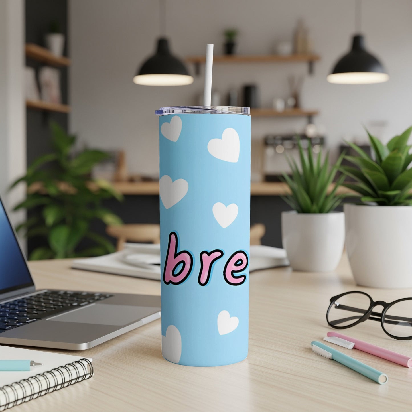 Light blue tumbler with white hearts and "bre" text.