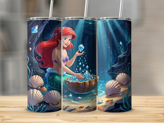 Ariel the mermaid holds gems from a treasure chest on a sandy seabed.