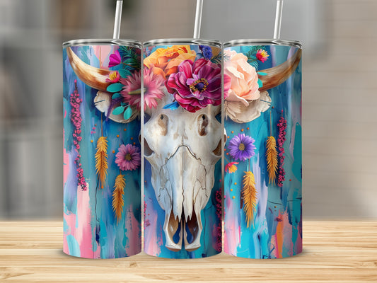 Bull skull adorned with colorful flowers and feathers on a vibrant painted background.