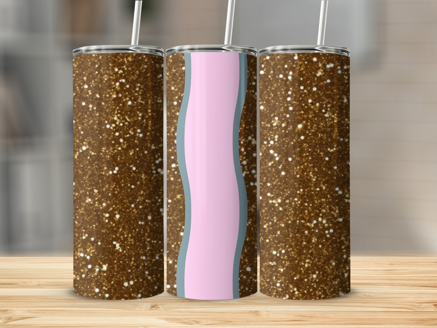 Three glitter tumblers with wavy pink and blue design on a wooden surface.