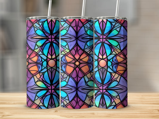 Three stained glass pattern tumblers with straws on a wooden table.