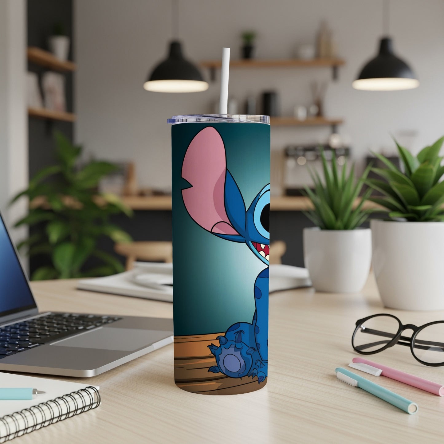 Stitch character on a blue tumbler with straw on a desk.