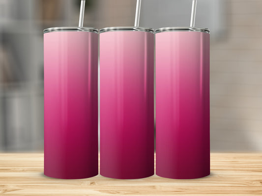 Three pink ombre tumblers with straws stand on a wooden surface.