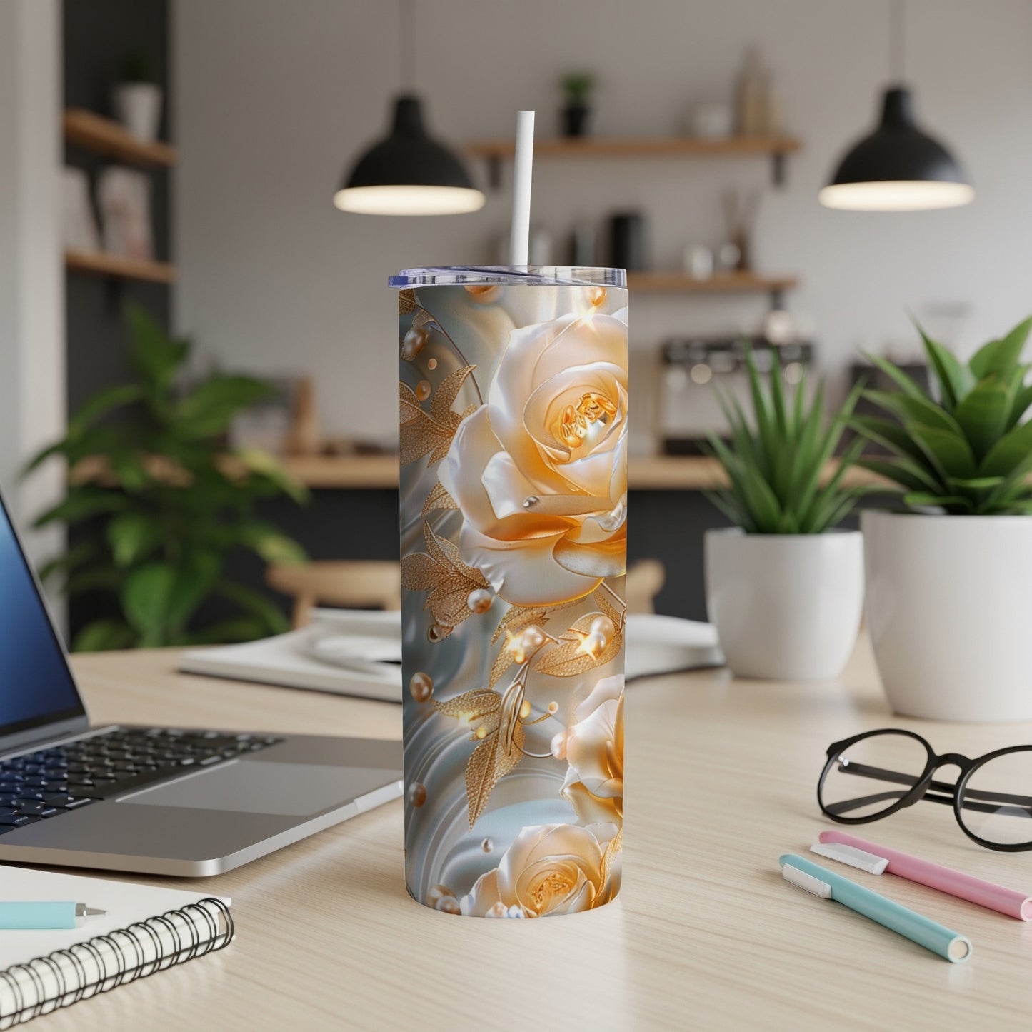 Gold floral tumbler with pearls and straw on a desk.