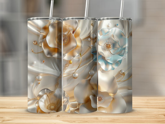 Three ornate, metallic tumblers with floral and pearl embellishments on a wooden surface.