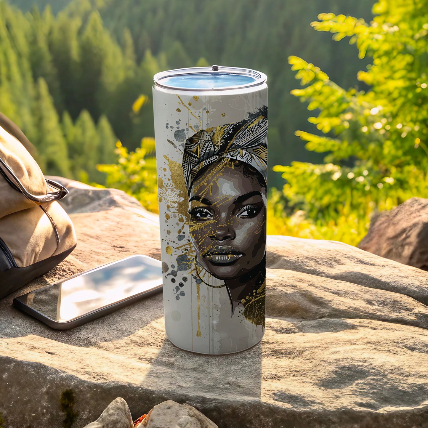 White tumbler with gold accents and a woman's face on it, outdoors.