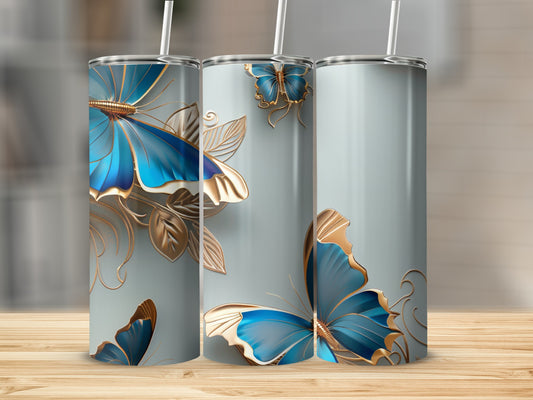 Three tumblers with blue butterflies and gold accents on a wooden surface.