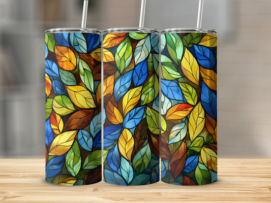 Three stained-glass effect tumblers with colorful leaf patterns on a wooden surface.