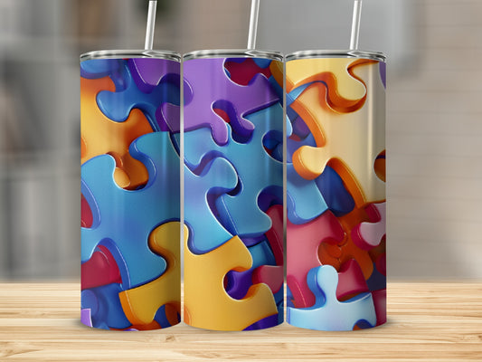 Three colorful puzzle pieces tumblers with straws on a wooden surface.