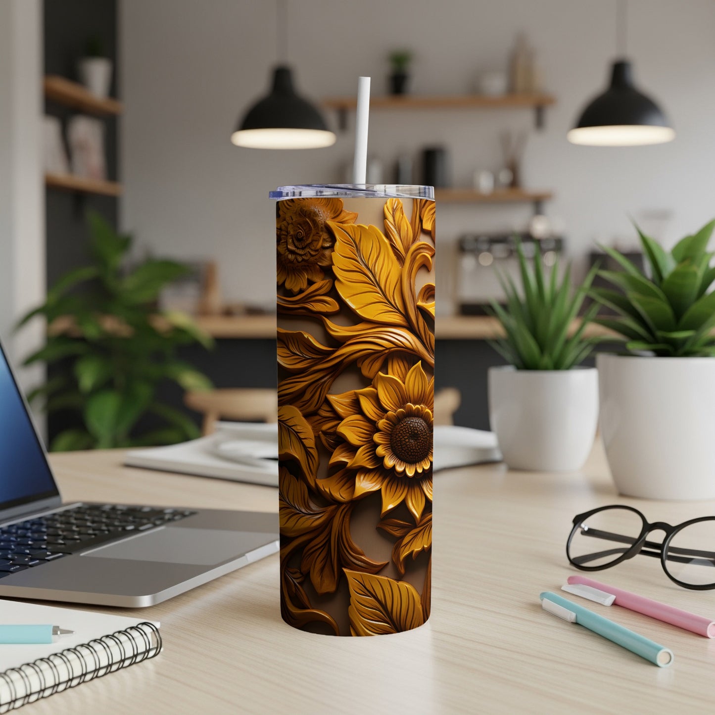 Tall brown tumbler with carved floral sunflower design and straw.