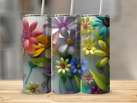 Three tumblers with colorful floral designs sit on a wooden surface.