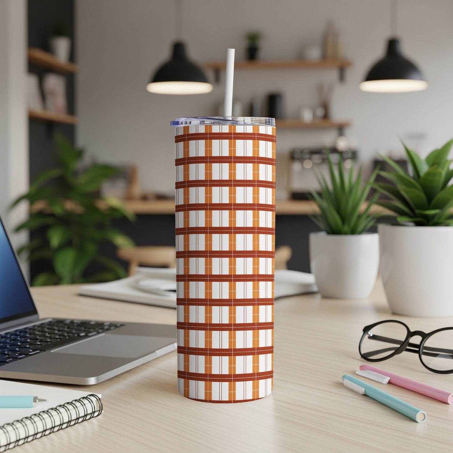 Tall, skinny tumbler with a brown and white plaid pattern and straw.