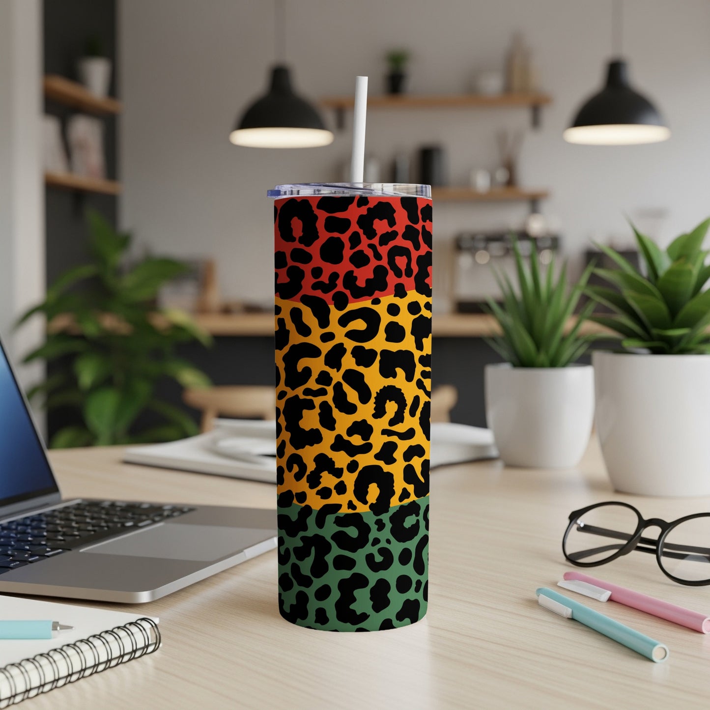 Tall tumbler with red, yellow, and green leopard print and a straw.