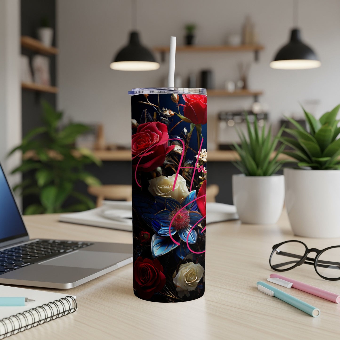 Tall tumbler with a floral design featuring roses on a desk.