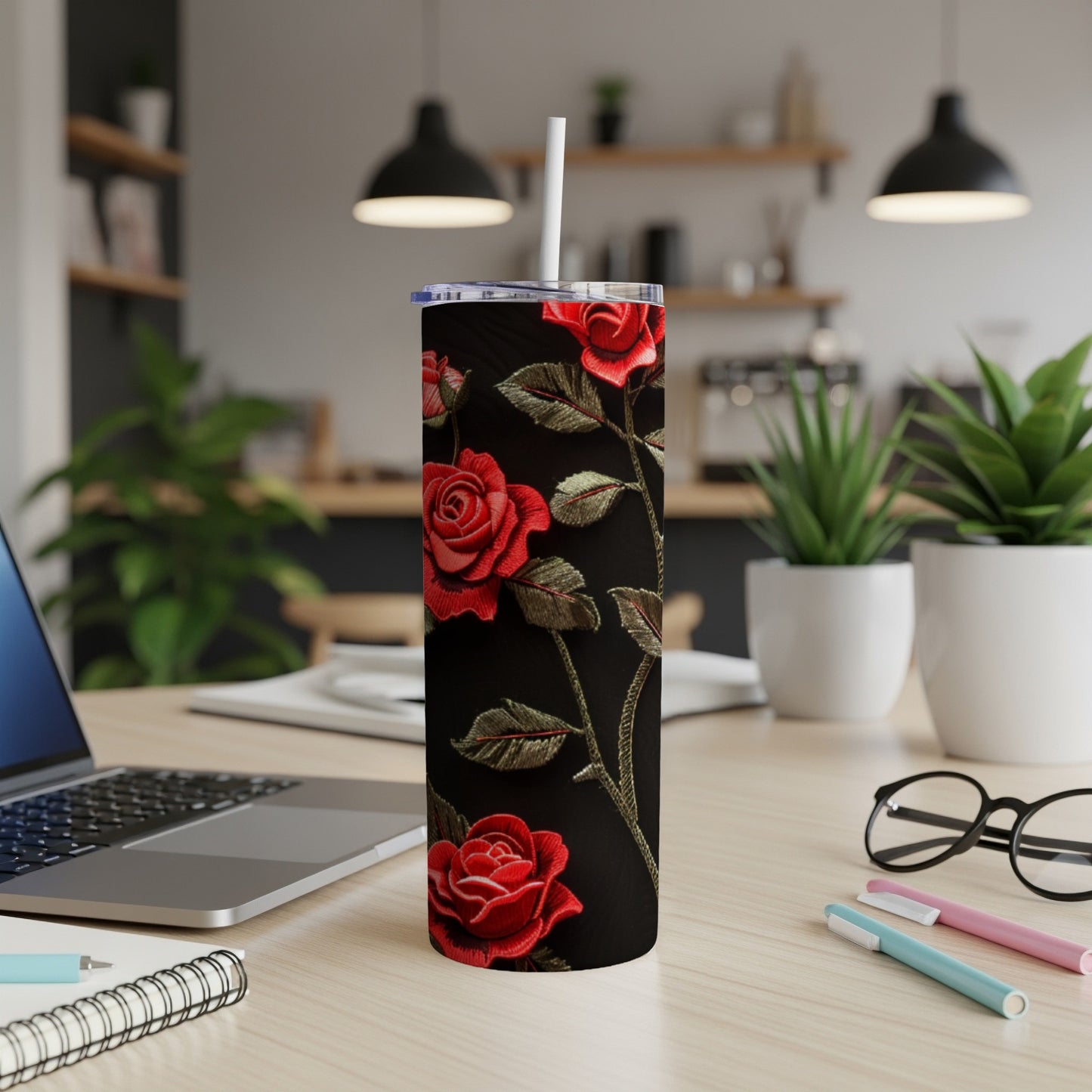 Red roses with green leaves on a black background adorn a stainless steel tumbler.