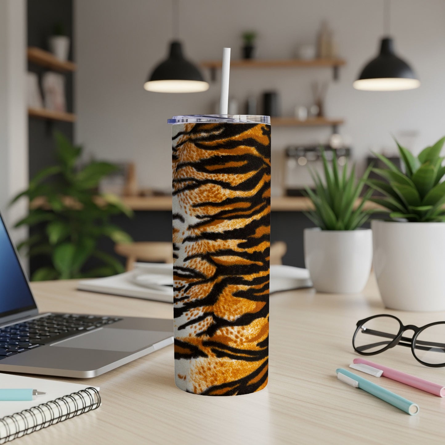 Tall tumbler with an orange and black tiger stripe pattern and a white straw.
