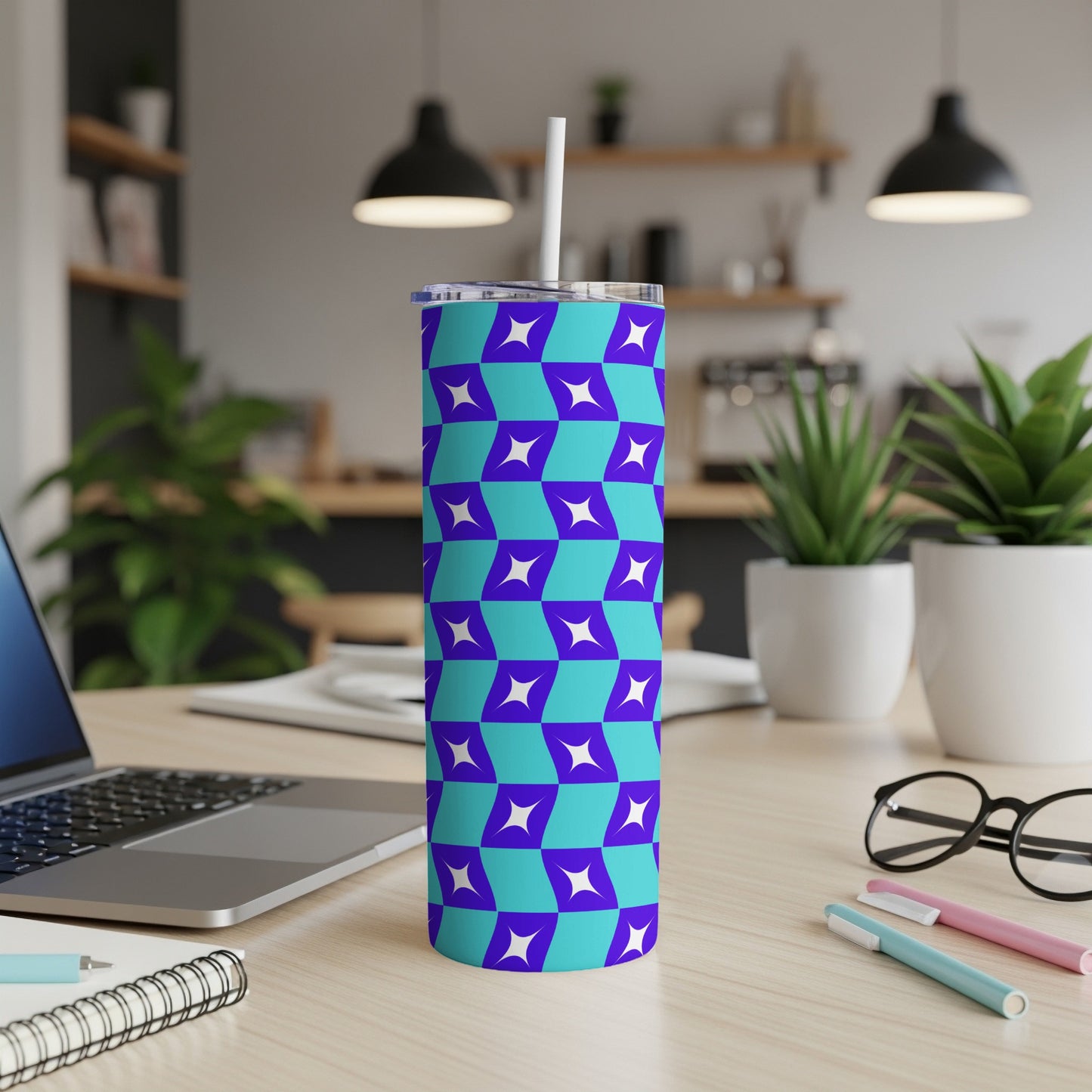 Blue and purple geometric pattern tumbler on a desk with a laptop and plants.