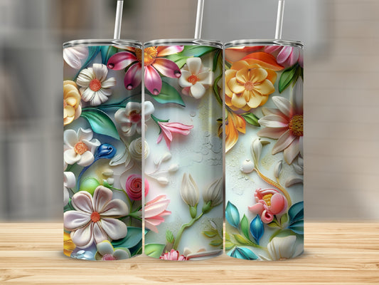Three tumblers featuring colorful embossed floral designs on a wooden surface.
