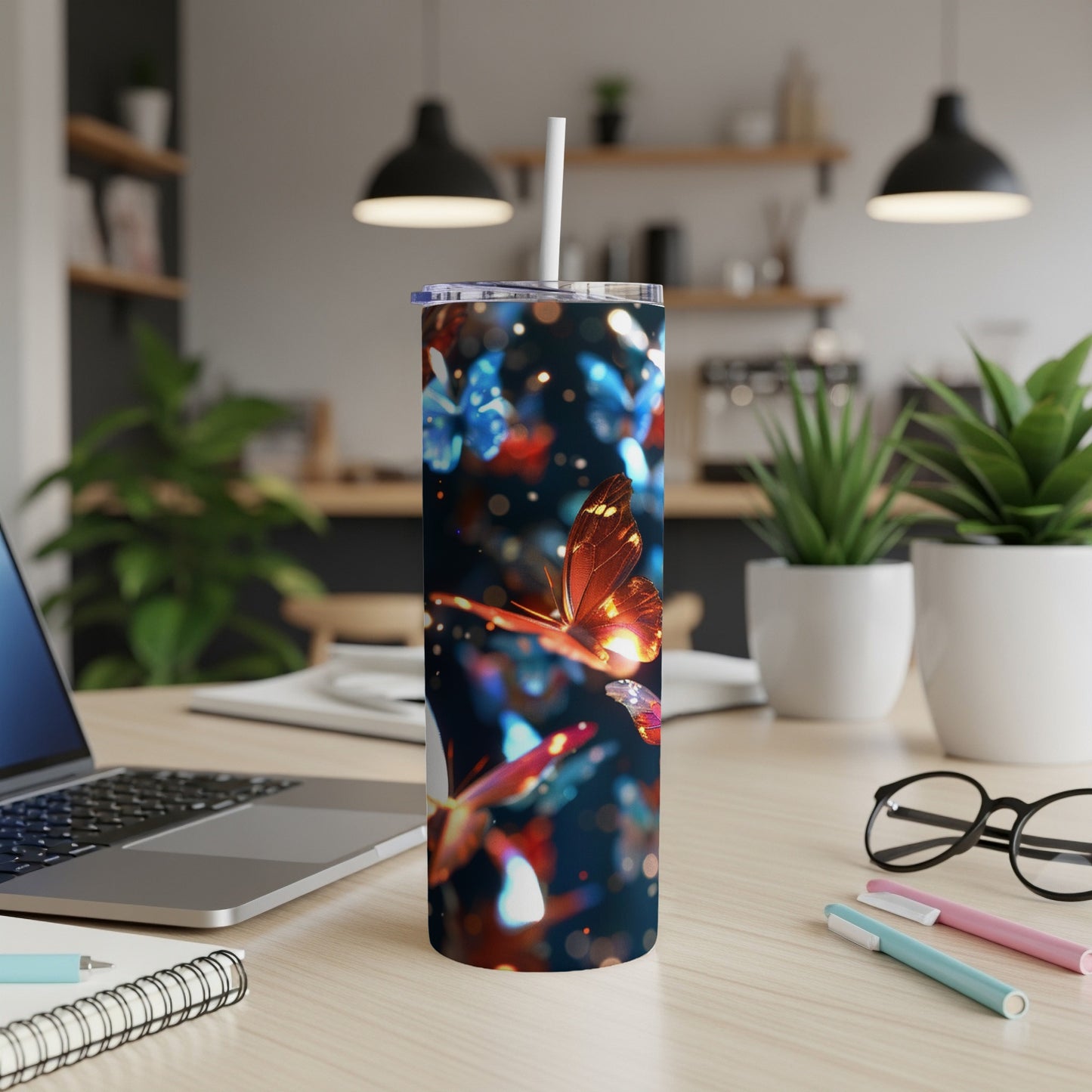 Tumbler with glowing orange butterflies and bokeh lights on a desk.