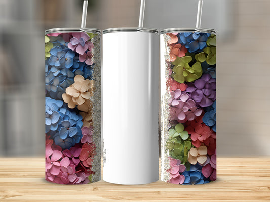Three tumblers on a wooden surface, two with colorful floral patterns.