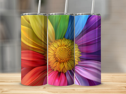 Three colorful tumblers with rainbow flower designs stand on a wooden surface.