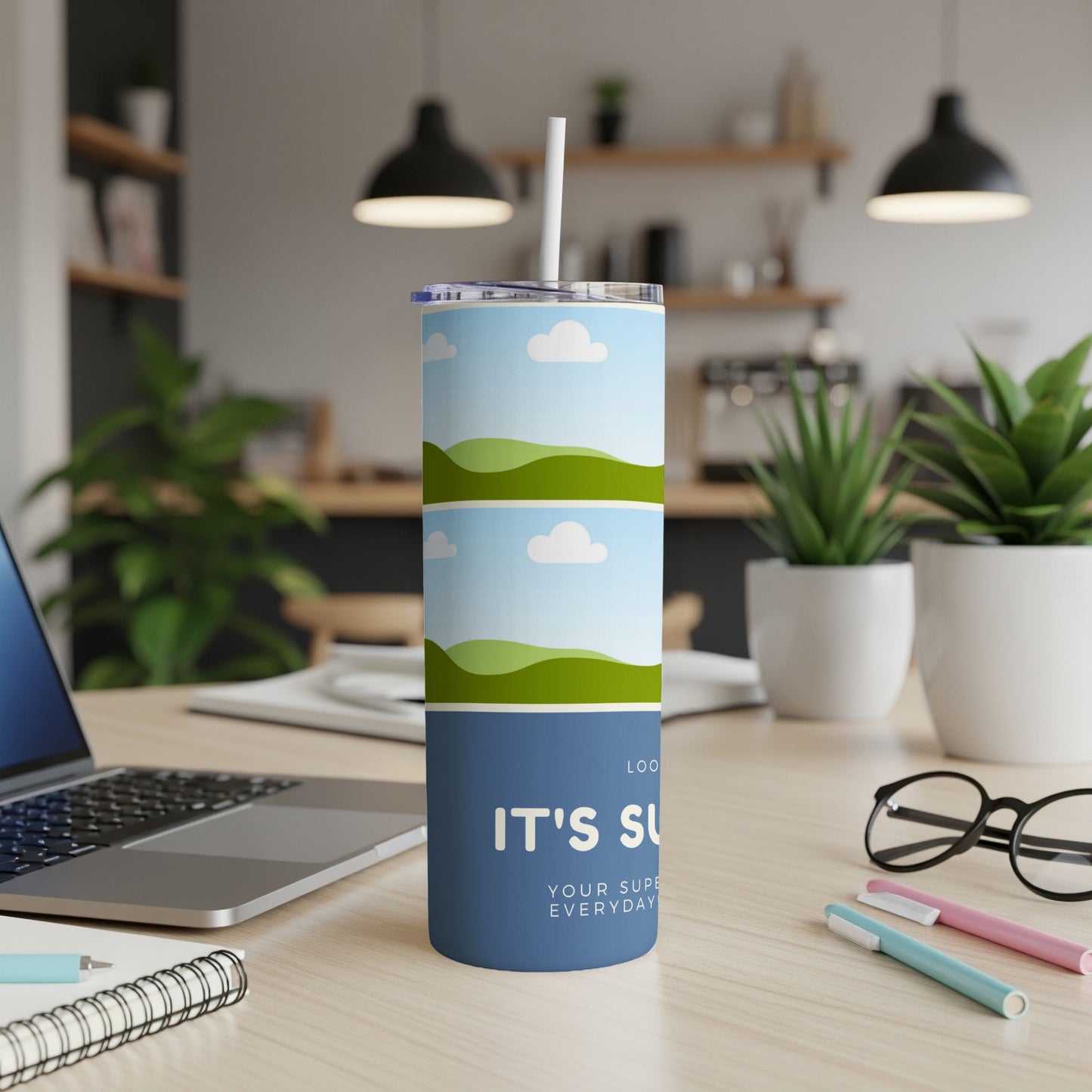 Blue tumbler with landscape and sky design and text "IT'S SU YOUR SUPE EVERYDAY".