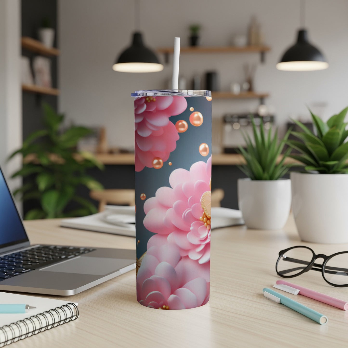 Floral pattern tumbler with pearls on a desk next to a laptop.