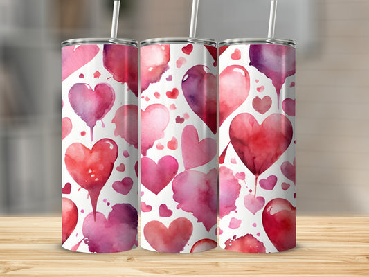 Three tumblers with watercolor heart patterns in pinks and reds.