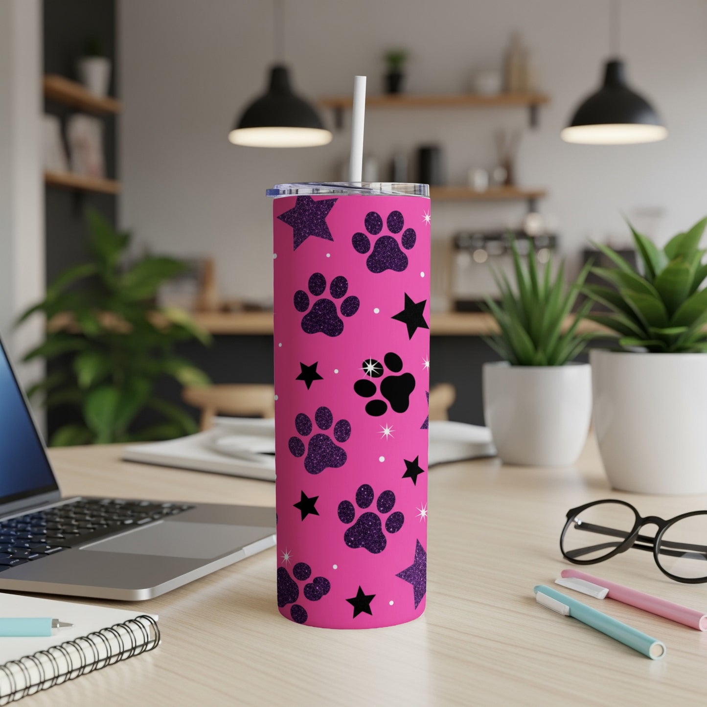 Pink tumbler with paw prints and stars, featuring a straw.