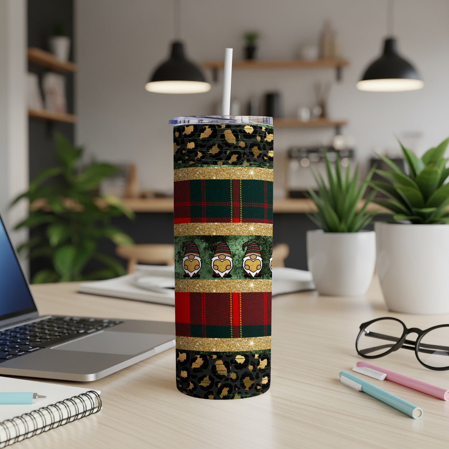 Tumbler with gnome, plaid, and leopard print pattern on a desk.