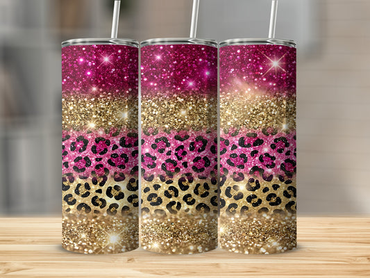Glittering pink and gold leopard print tumbler with straw, on a wooden surface.