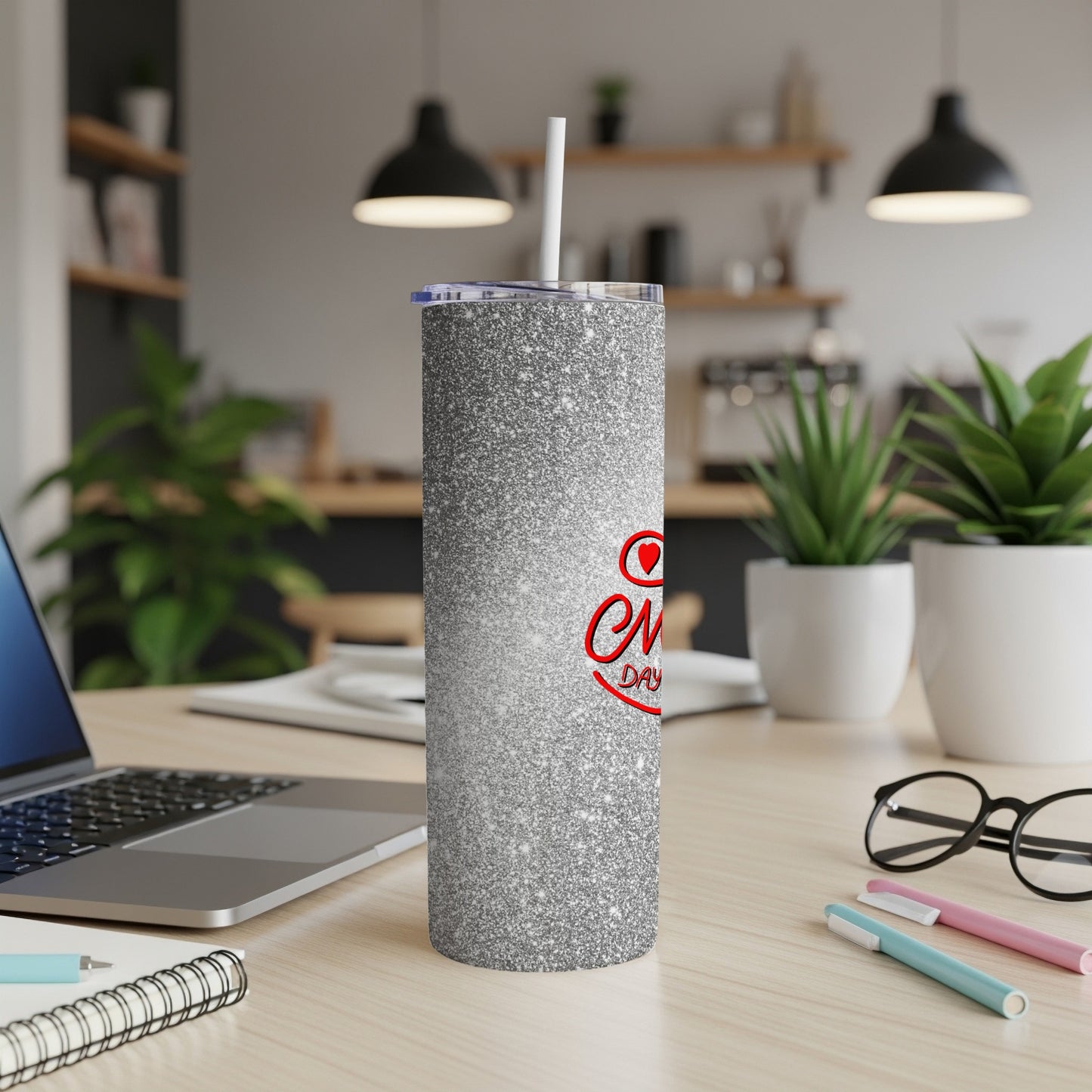 Silver glitter tumbler with "Everlasting Love" text and straw on a desk.