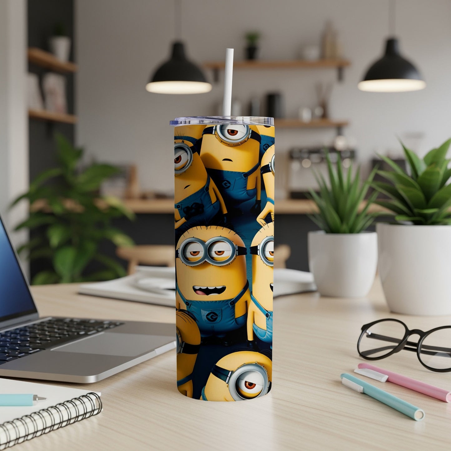 Minions characters in blue overalls wrap around a white tumbler with a straw.