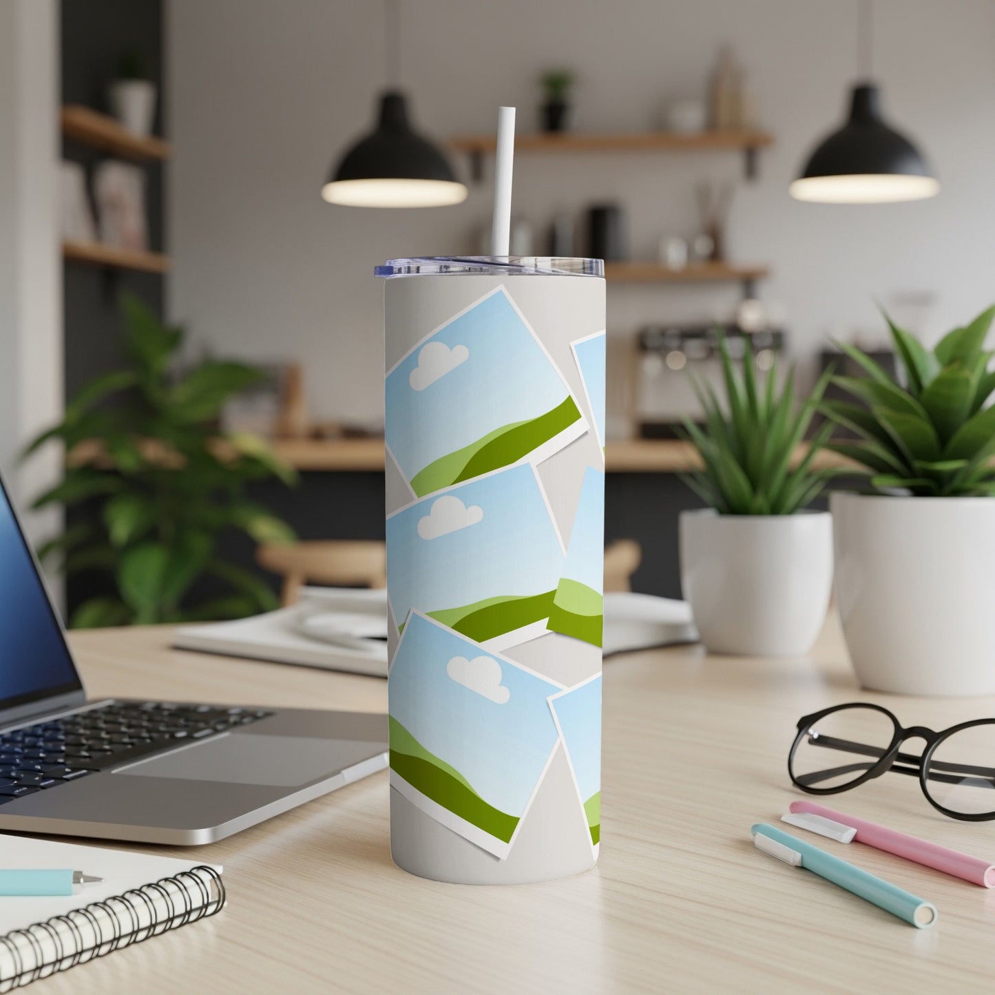 White tumbler with a collage of landscape photos and a straw.