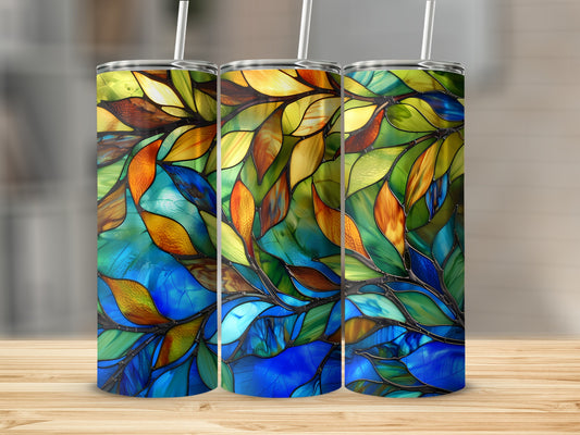 Three tumblers with stained glass leaf pattern on a wooden surface.