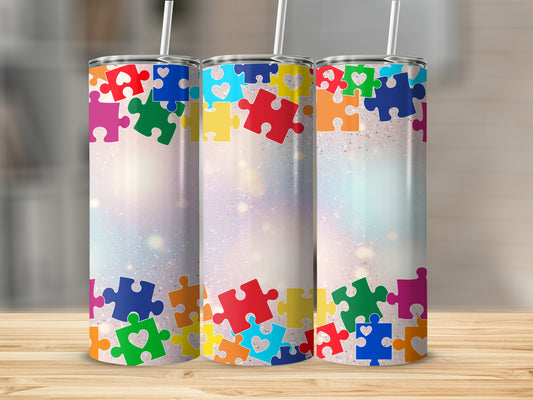 Three colorful autism puzzle piece tumblers with glitter and bokeh background.
