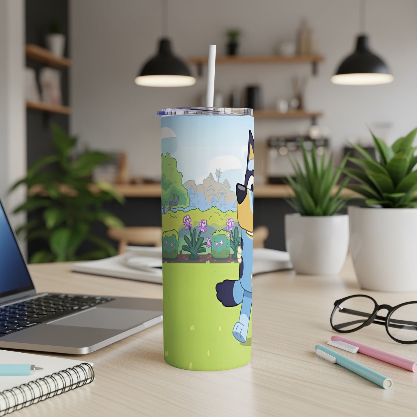 Bluey character on a green grassy field with flowers, on a tumbler.