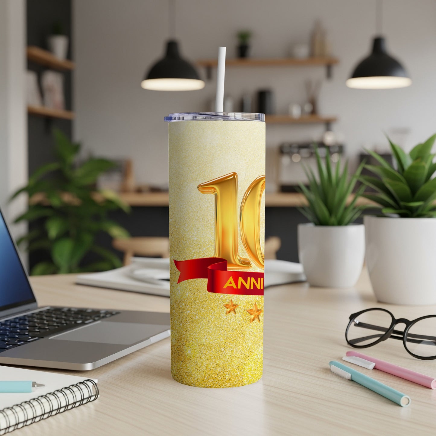 Gold 10th Anniversary tumbler with red ribbon and stars.