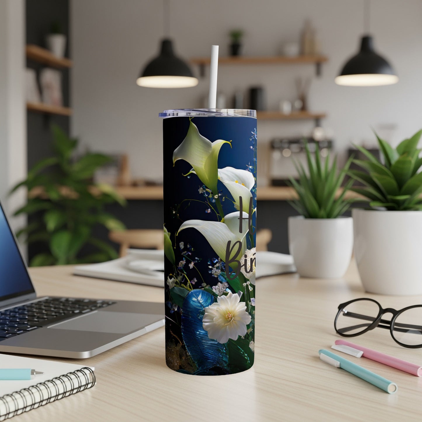 White calla lilies and text on a dark tumbler with a straw.
