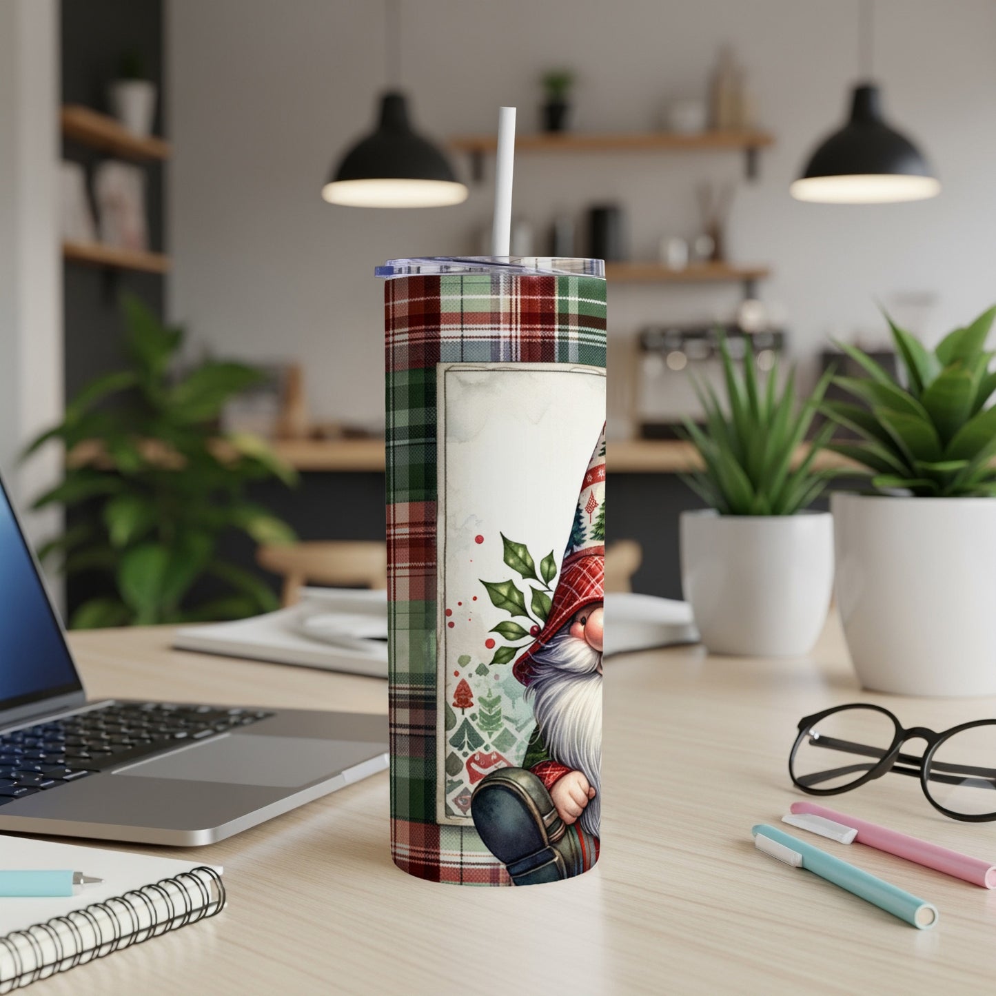 Christmas gnome tumbler with plaid accents on a desk.