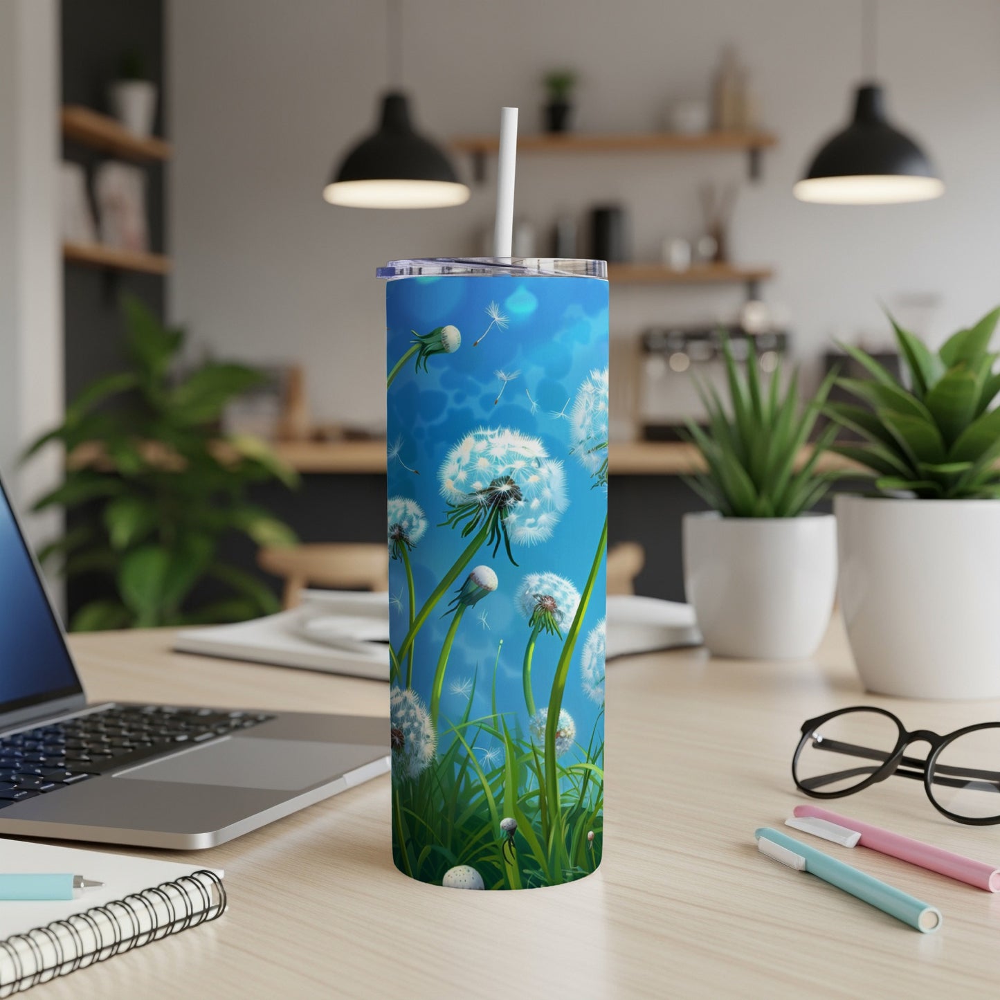 Tumbler with dandelions and green grass against a bright blue sky.