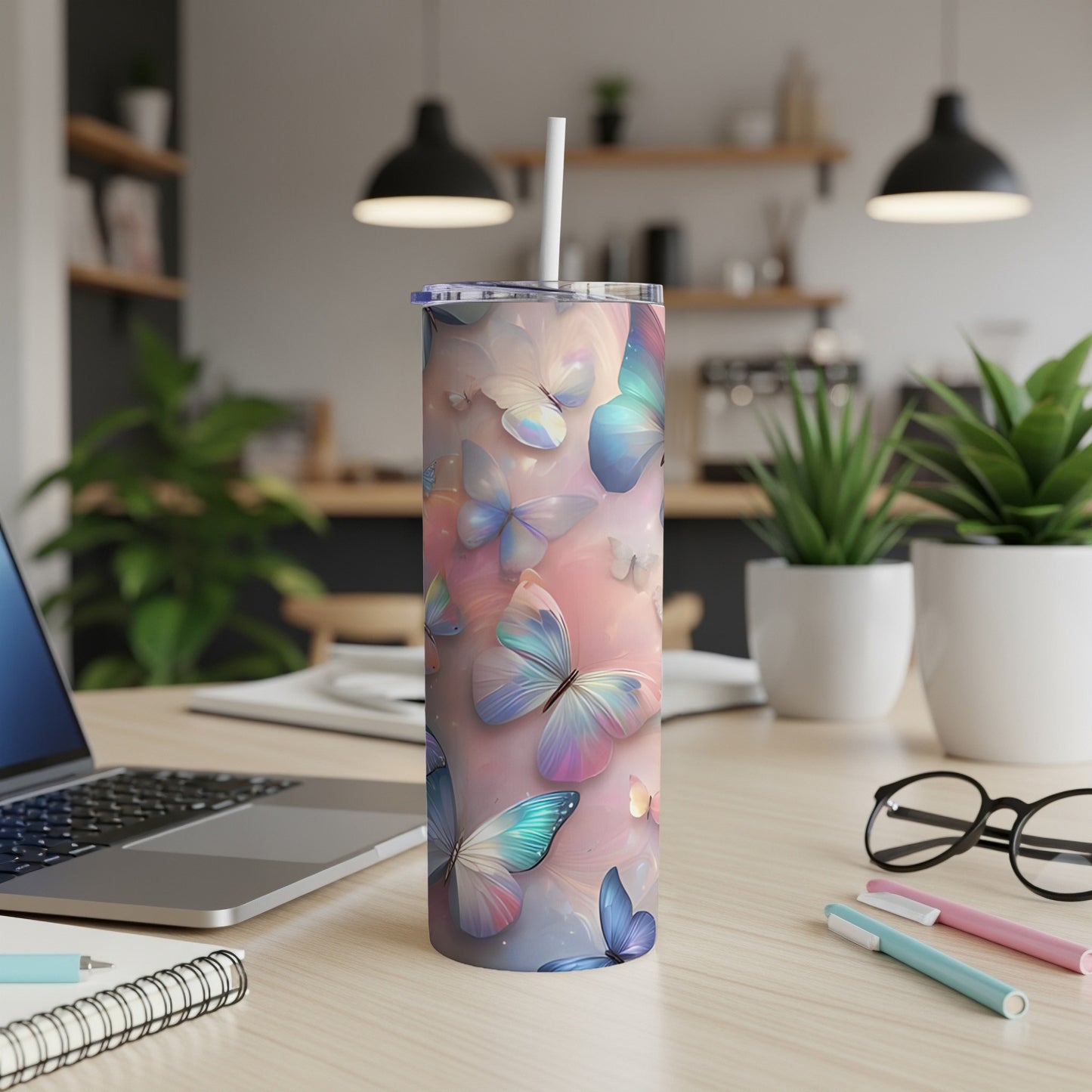 Pink and blue pastel butterflies wrap around a skinny tumbler with a straw.
