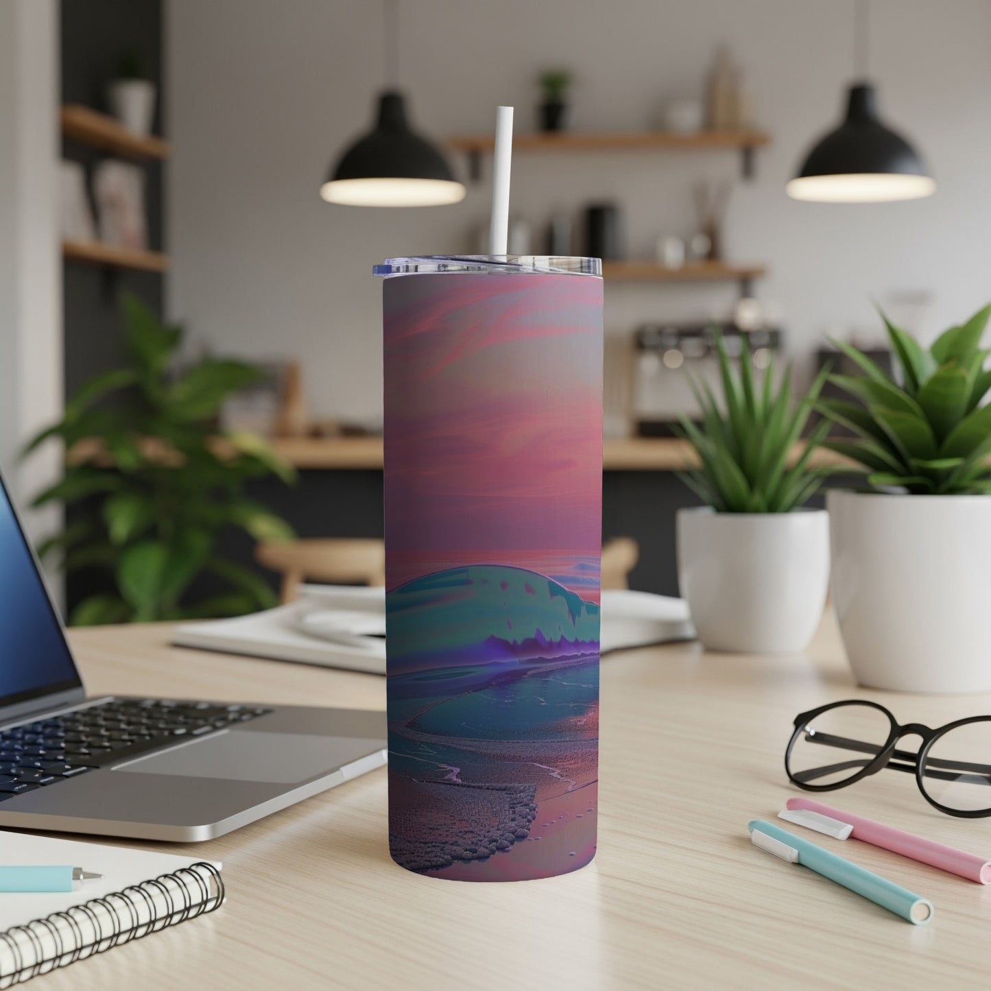 Tall tumbler with a sunset ocean wave design sits on a desk.