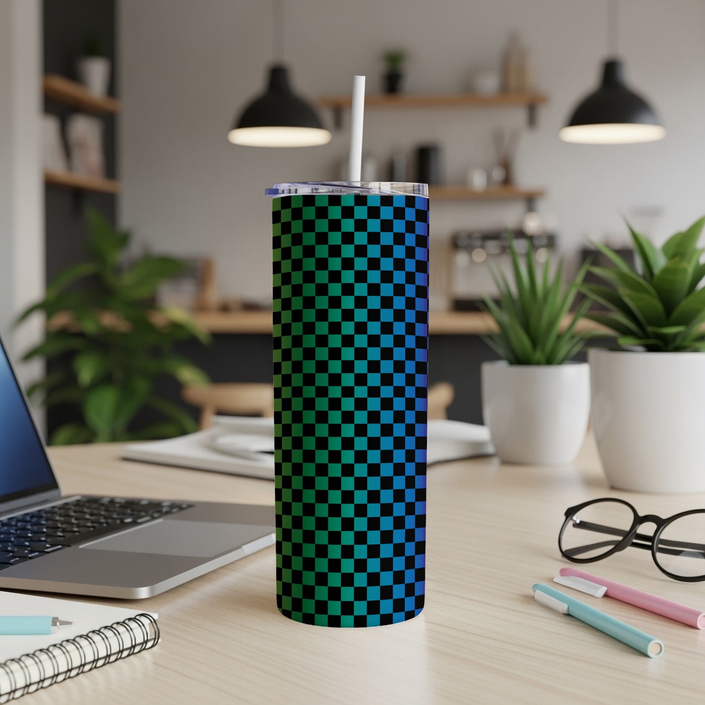 Tall tumbler with a blue and green checkered pattern on a desk.