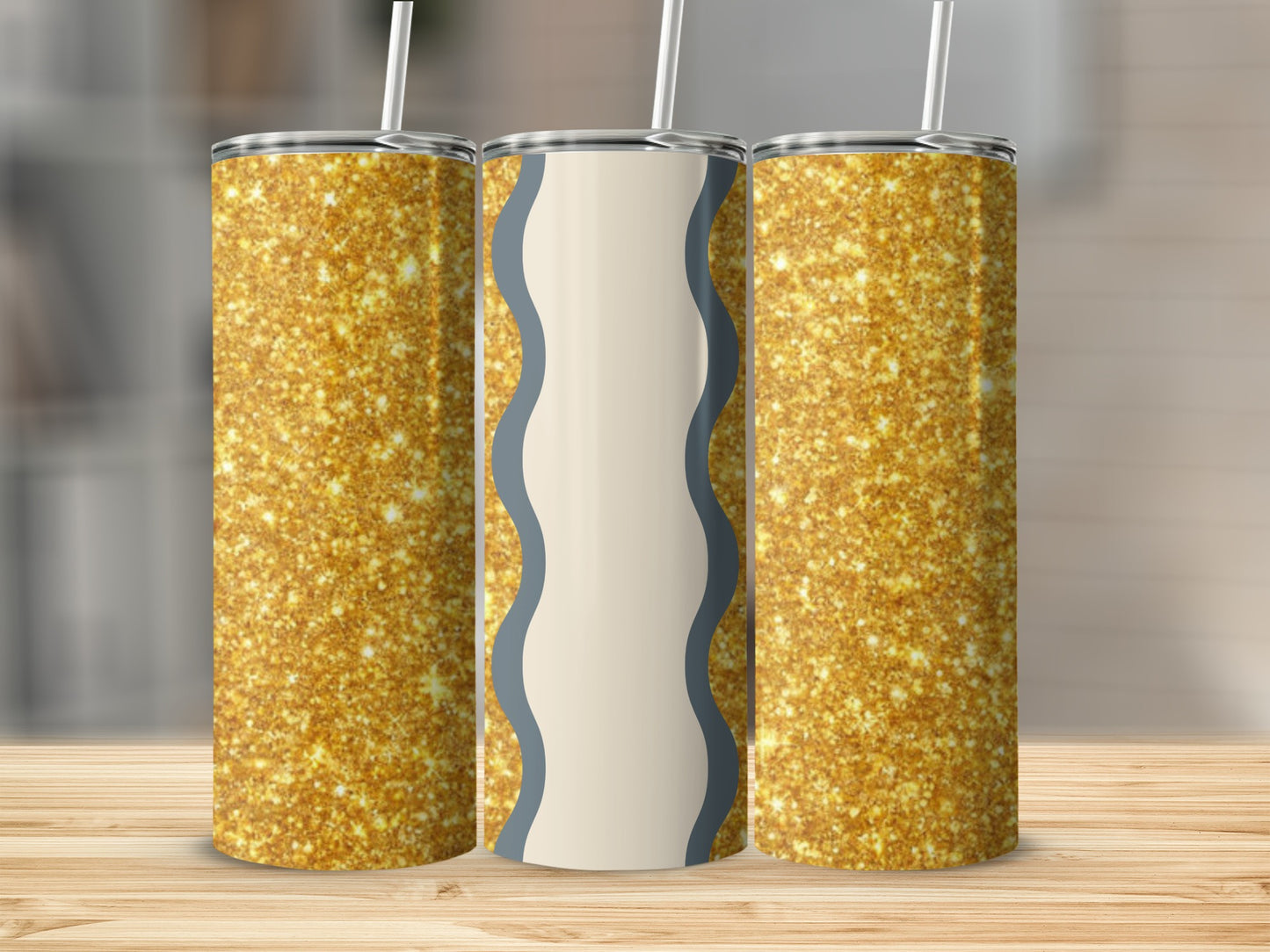 Three glittery gold tumblers with straws on a wooden surface.